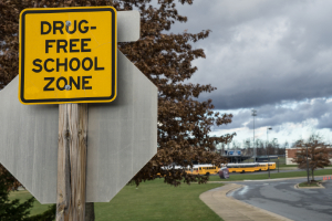 Drug free school zone sign on road. Facing charges on a drug free school zone.
