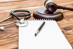 notepad with gavel and stethoscope