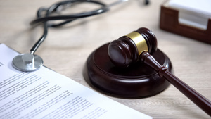 Stethoscope on table, gavel lying on sound block, injury compensation, crime