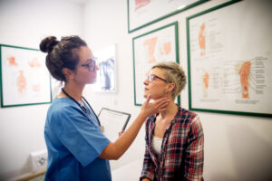 Professional beautiful medical doctor examining patient in her office. 