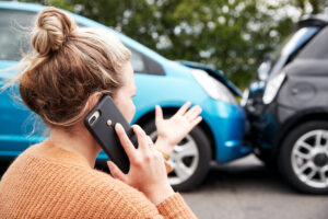 Female Motorist Involved In Car Accident Calling Insurance Company Or Recovery Service 