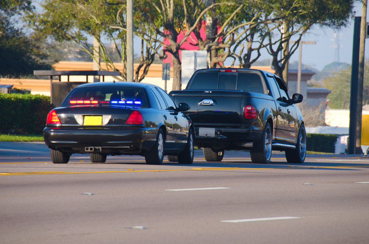 An unmarked police car has pulled over a truck for a traffic violation