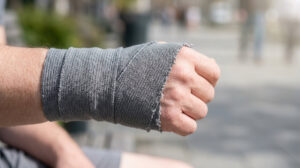 A person's hand and wrist wrapped in a compression bandage after a painful fall.