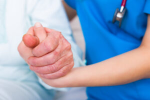 Caregiver holding an elderly nursing home resident's hand