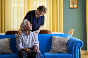 Professional helpful caregiver and a senior man during home visit Professional helpful caregiver and a senior man during home visit