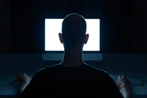 Man with criminal intentions hacking from a desktop computer