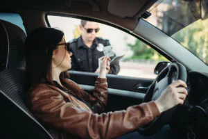 Male cop in uniform writes a fine to female driver