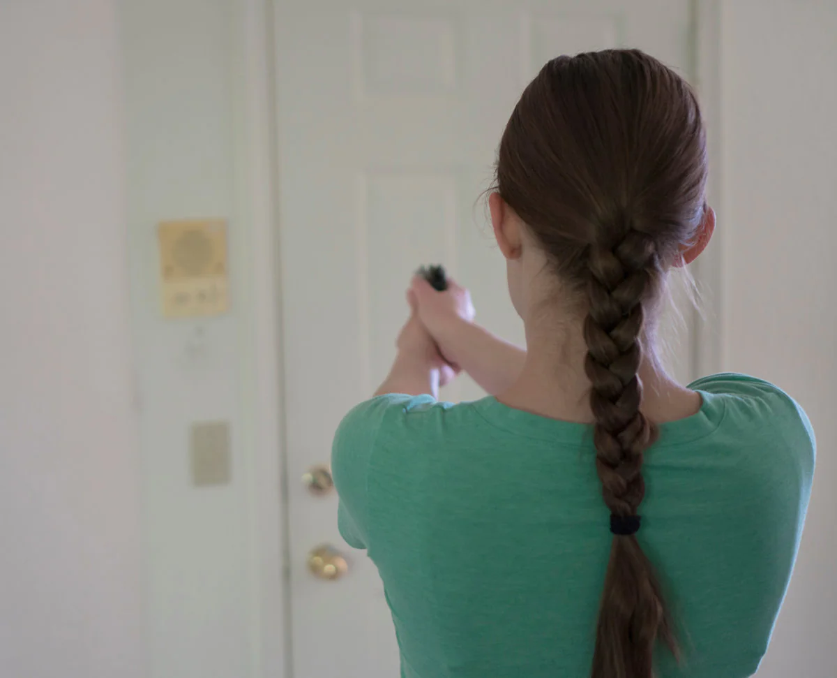 Woman pointing gun at door. Intruder concept.